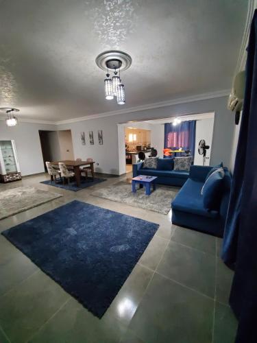 10月6日市にあるSpacious 3 bedroom apartment - FAMILIES ONLYの青いソファとテーブルのあるリビングルーム