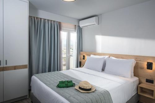 a hotel room with a bed with a hat on it at Nuovo Crete By Sea in Amoudara Herakliou