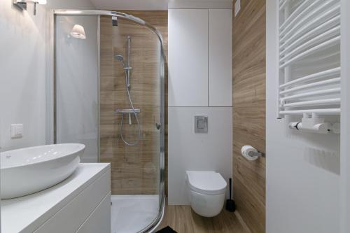 a bathroom with a shower and a sink and a toilet at Apartament Muszelka Jantar TriApart in Jantar