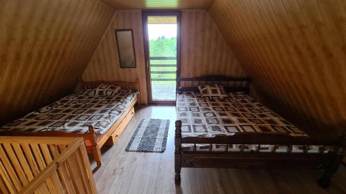 Duas camas num quarto com uma janela em Domek u Heleny em Jeleniewo