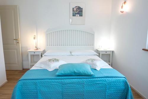 1 dormitorio con 1 cama azul y blanca y 2 almohadas en Casa del Fattore, en Osimo