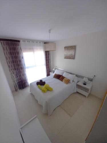 una camera da letto bianca con un letto e una finestra di Atico con piscina privada a Vera