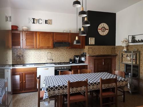 una cocina con mesa con sillas y mesa y una cocina con en Villa Flora Affittacamere, en Luni