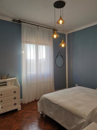 a bedroom with a bed and a dresser and a window at Villa Flora Affittacamere in Luni