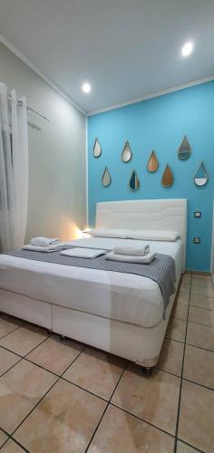 a bedroom with a large bed with a blue wall at Nina Apartment in Chania Town