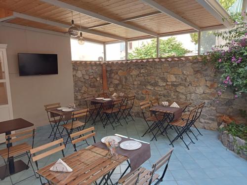 a restaurant with tables and chairs and a stone wall at Borgo 800 in San Nicola Arcella