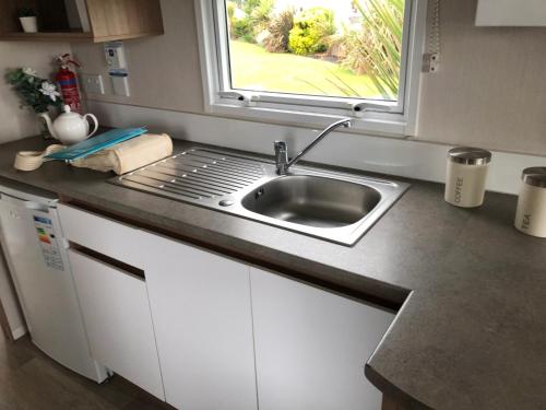 a kitchen counter with a sink and a window at The Populars, 18 in Rhyl