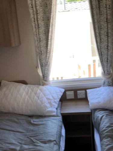 a bedroom with a bed and a window at The Populars, 18 in Rhyl