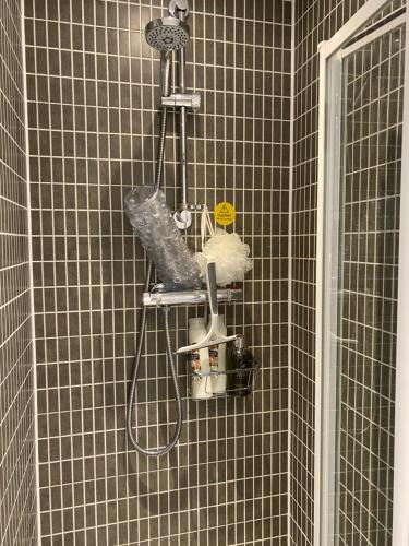 a shower with a rack with a tennis racket at Stylish 3 bed home with allocated parking for 2 in Liskeard