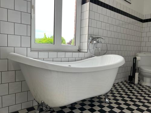 a white bath tub in a bathroom with a window at City-Kesselhaus-Stendal in Stendal