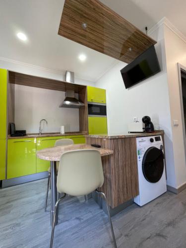 a kitchen with a table and a washer at Ria Studios in Olhão