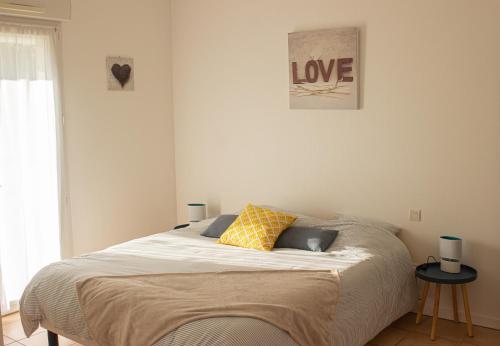 un letto con due cuscini sopra in una camera da letto di Villa Saint Fort - Résidence Services a Saint-Fort