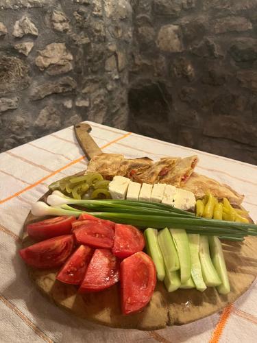 a plate of food with vegetables on a cutting board at Molla Guest House in Theth