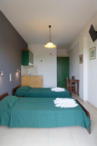a bedroom with two beds with green sheets at Habitat Villa Corfu in Dassia