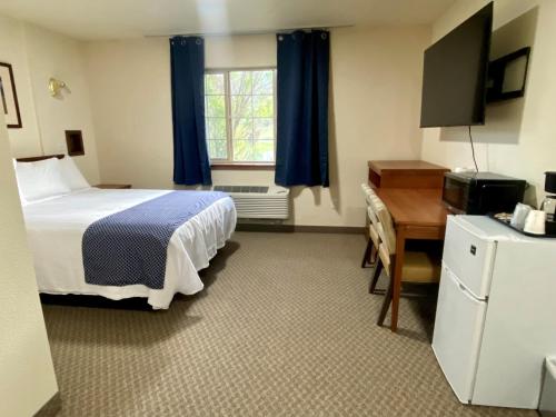 ChallisにあるRED ROCK LODGEのベッドとデスクが備わるホテルルームです。