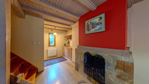 a living room with a red wall and a fireplace at Hotel FAMIL - adults only in Bansko