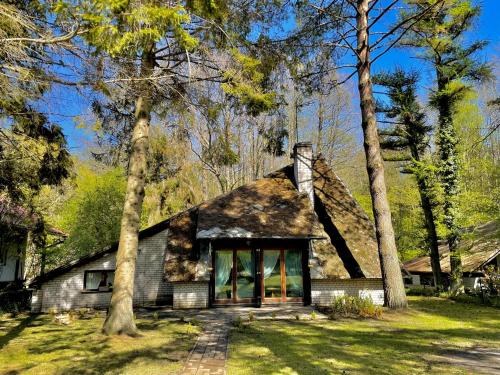 a house with a thatched roof in the woods at "Sosnowy Domek" PODDĄBIE, blisko Ustki! 500m od plaży in Poddąbie