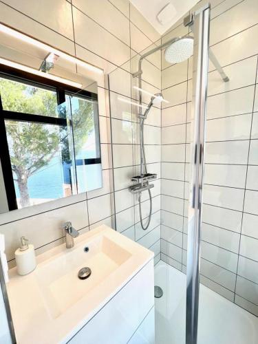 une salle de bain avec un lavabo et une douche dans l'établissement Magnifique Villa Neuve Vue Mer, à Cavalaire-sur-Mer