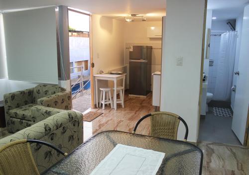 uma sala de estar com um sofá, uma mesa e uma cozinha em Acogedor departamento en Barranco em Lima