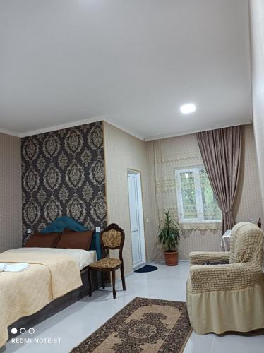 um quarto com uma cama e uma cadeira em zaza house em Kutaisi
