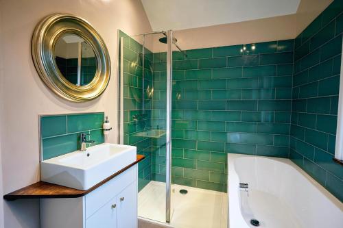 a bathroom with a sink and a tub and a mirror at Boscobel Apartments Up in Winchester
