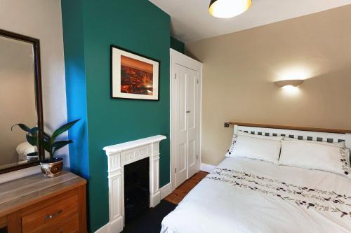 a bedroom with a white bed and a green wall at Boscobel Apartments Up in Winchester