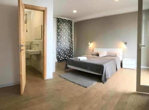 Un dormitorio con una cama y un baño con lavabo. en VILLA ZEN TAORMINA, en Taormina