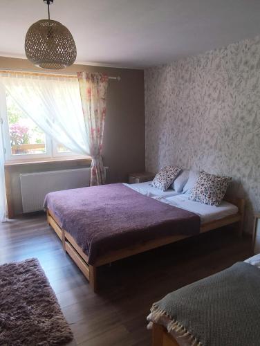 a bedroom with two beds and a window at Gościnna Chata in Jaworki