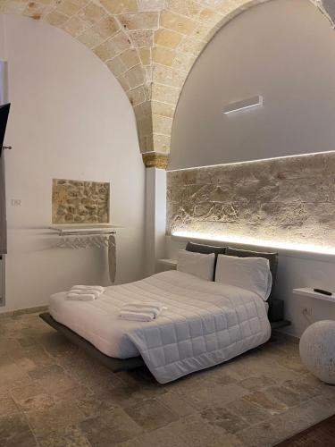 a bed in a room with a stone wall at Suite87 in Mesagne