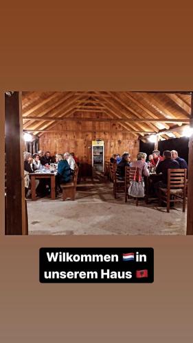 a group of people sitting at tables in a building at Guesthouse Skender Selimaj in Valbonë