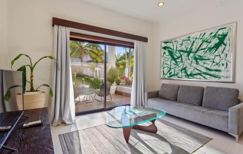 a living room with a couch and a glass table at The Ellysian Boutique Hotel in Placencia Village