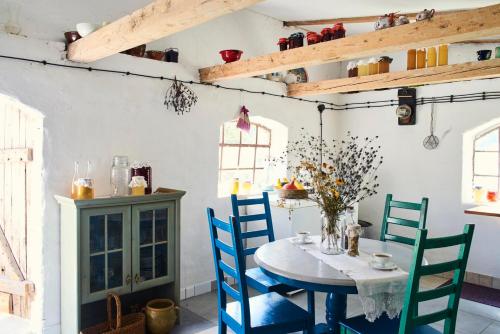 une salle à manger avec une table et des chaises bleues dans l'établissement Pilwa 17 - Glamping na Mazurach, à Węgorzewo
