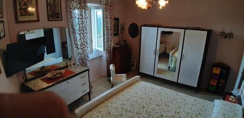 a bathroom with a large mirror and a television at Casa sotto il Castello in Monti di Licciana Nardi