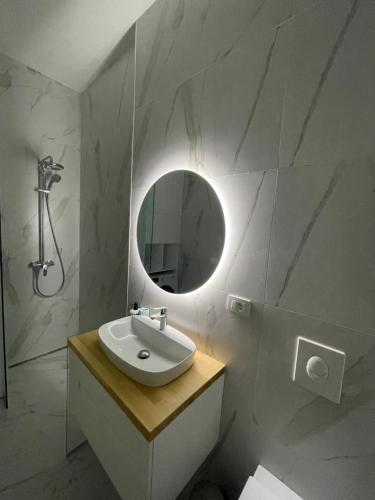 Baño blanco con lavabo y espejo en Heaven Residence - Green Coast Resort, Palasë en Llogara
