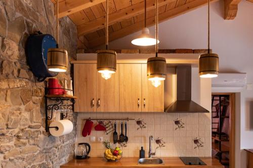 a kitchen with wooden cabinets and pendant lights at Rašpor in Rašpor