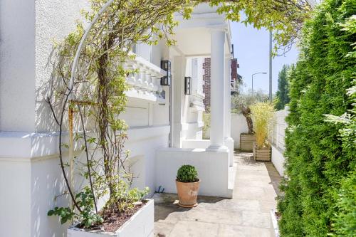 uma casa branca com plantas ao lado dela em The White House - Deauville em Deauville