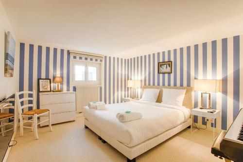 um quarto com uma grande cama branca e uma secretária em The White House - Deauville em Deauville