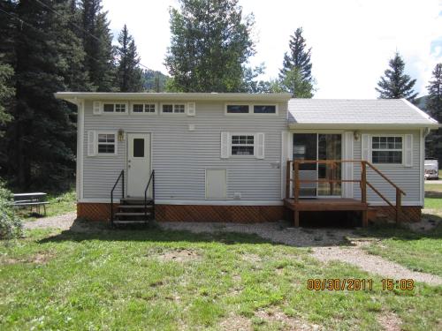 a tiny house with a porch and a deck at Circle K Ranch in Rico