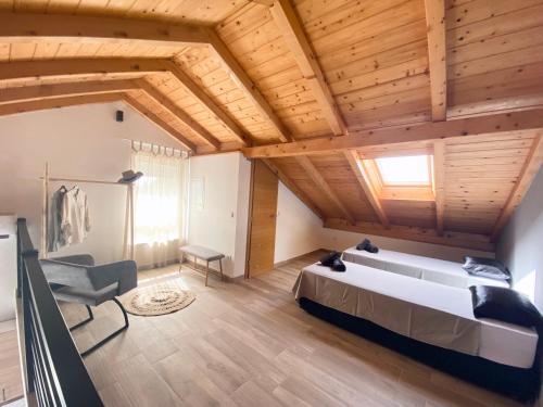 een slaapkamer met een groot bed in een kamer met houten plafonds bij Apartment house GAIA in Gajac