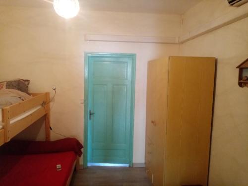 une porte bleue dans une chambre avec un lit et une armoire dans l'établissement Séjour Valras-Plage T3 Vue sur Mer - 50m centre et mer, à Valras-Plage