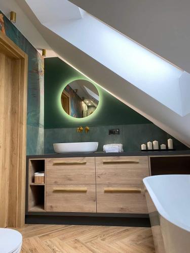 a bathroom with a sink and a mirror at Dom z balią na Kaszubach-Widokova in Borucino