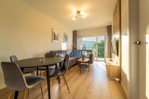 uma sala de estar com uma mesa e cadeiras e um sofá em Silver Apartments Mountain Aparts em Świeradów-Zdrój