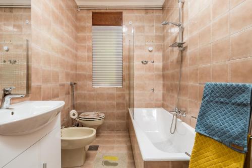 ein Badezimmer mit einer Badewanne, einem Waschbecken und einem WC in der Unterkunft Zen 6 in Viskovo