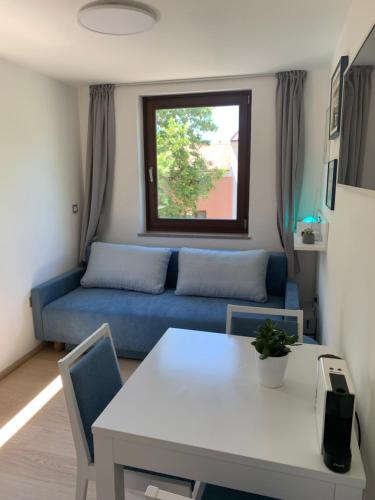 a living room with a blue couch and a table at Apartma Manuel in Izola
