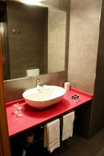 a bathroom with a red counter with a sink and a mirror at Casual Arriaga in Bilbao
