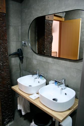 a bathroom with two sinks and a mirror at Casual Arriaga in Bilbao