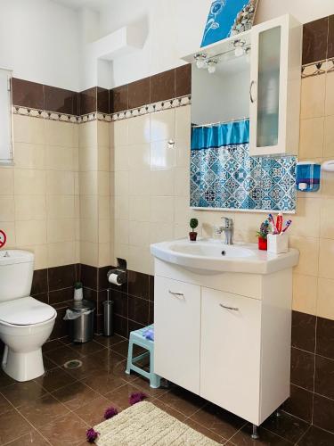 a bathroom with a white sink and a toilet at Mikro Amoni Beach Villa in Pefkali