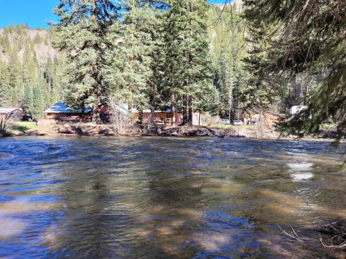 a view of a river with a cabin in the background at Circle K Ranch in Rico