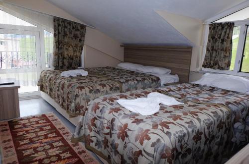 a hotel room with two beds and a window at SARIMESE OTEL in Demirci