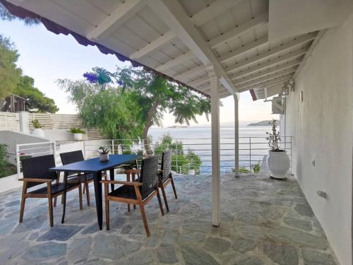 eine Terrasse mit einem Tisch und Stühlen unter einer Pergola in der Unterkunft Evgenia Seafront House in Skiathos-Stadt
